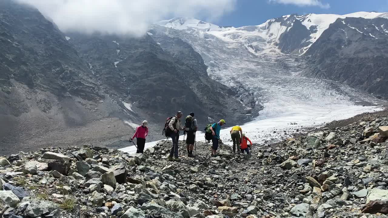 一个由6人组成的旅行团，背着小背包准备上山。视频素材