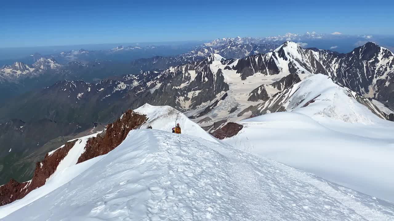 三名登山者从卡兹别克山顶一前一后地走下来视频素材