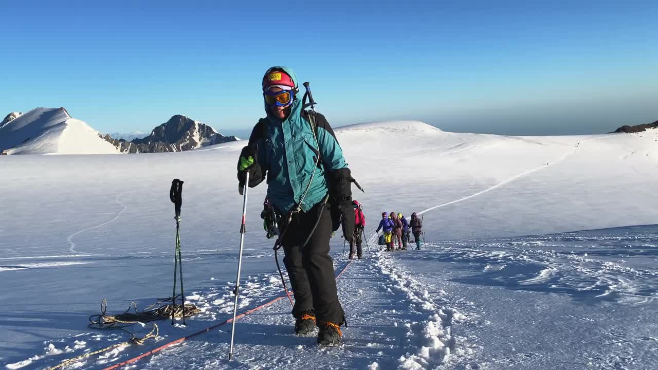 一群登山者正沿着一条被雪覆盖的小道上山。从北部攀登卡兹别克视频素材