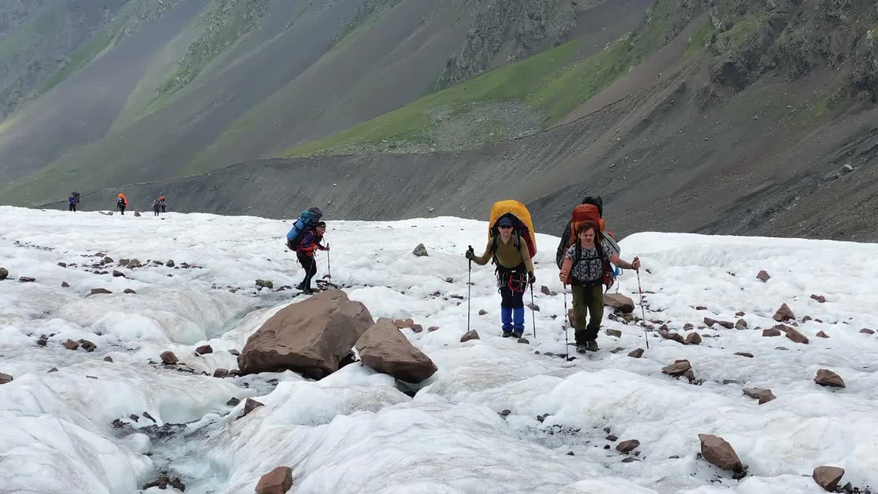 背着大背包的徒步旅行者沿着冰川行走。从北部攀登卡兹别克视频素材