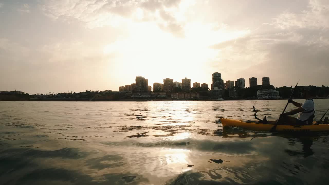 在地中海，一名划皮艇的运动员正把一条被鱼饵钩住的鱼拖出水面。视频素材