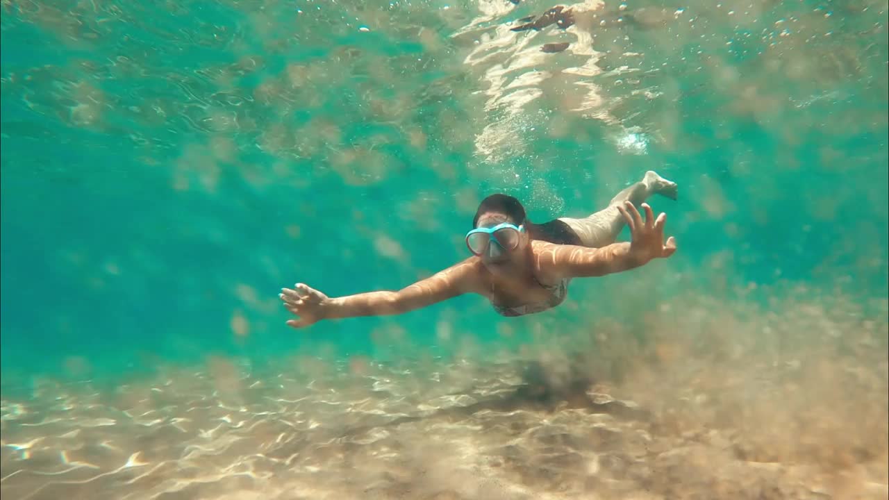 夏天，年轻的女士在地中海水下浮潜寻找鱼。视频素材