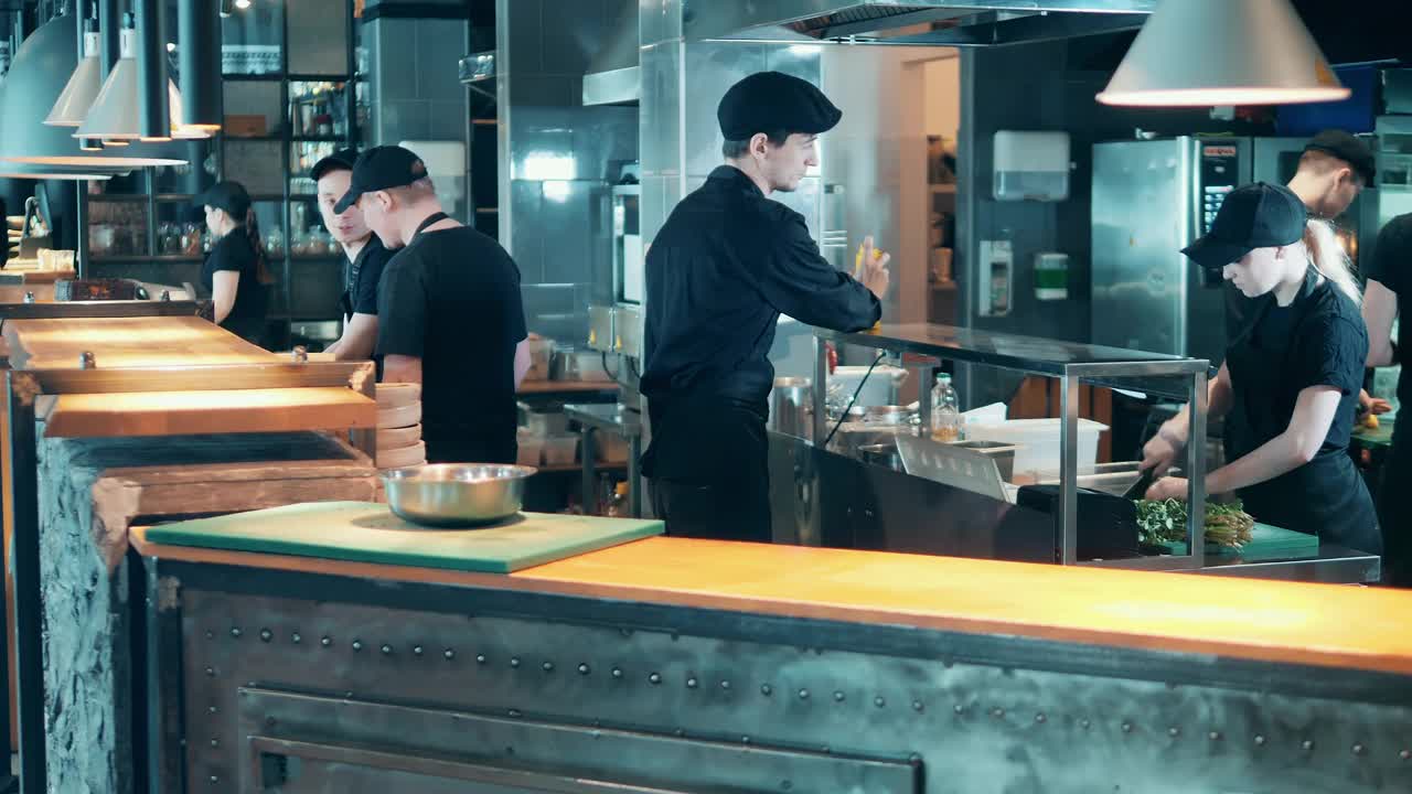 餐馆的厨师正在柜台后面烹饪食物视频素材