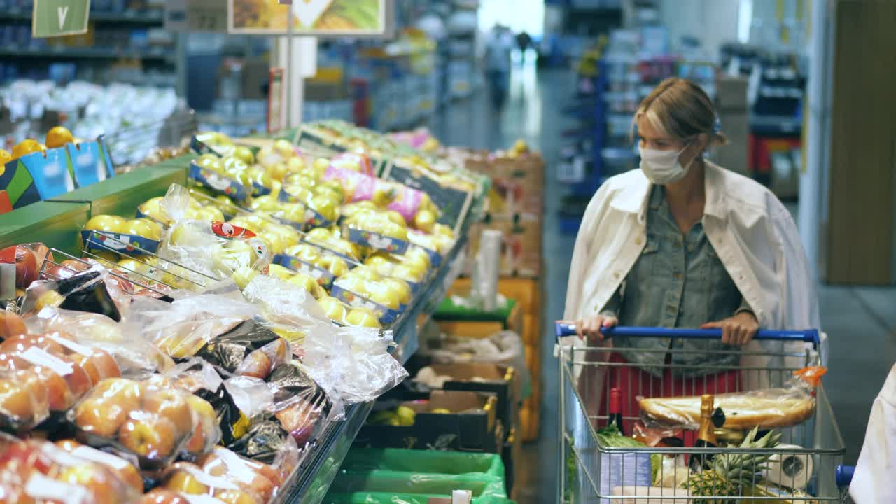 超市里和一位女士戴着口罩买水果视频素材