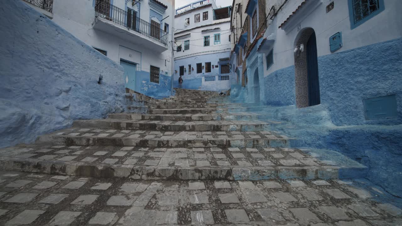 在Chefchaouen，前面显示了蓝色油漆房屋之间的楼梯。低角度的观点。摩洛哥、非洲视频素材