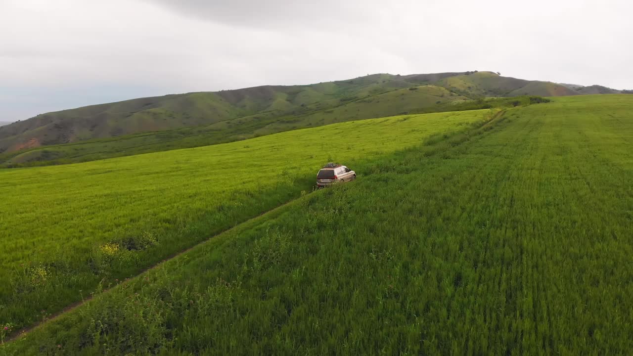 无人机拍摄显示平移视图4x4汽车驾驶在户外高草甸田在参观Vashlovani国家公园。格鲁吉亚，高加索地区的极限旅游。视频素材