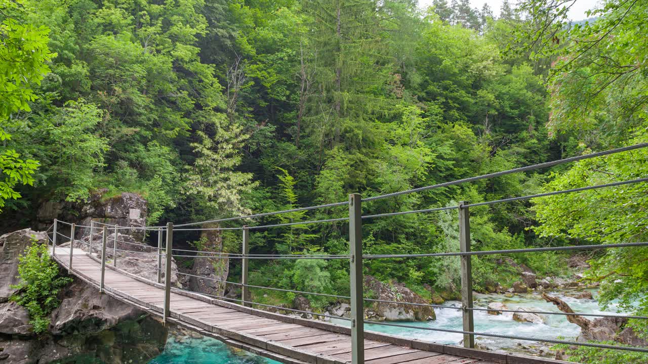 女游客徒步穿越山涧峡谷上的木桥视频素材