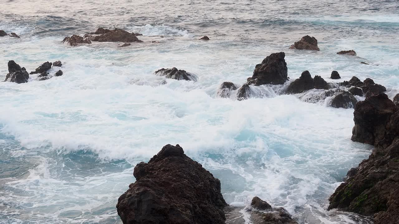 海浪撞击火山岩的海岸景观。视频素材