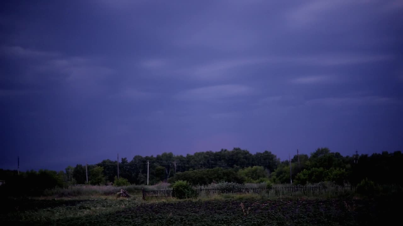 深蓝色的天空中闪过闪电，森林上空爆发了雷雨视频下载