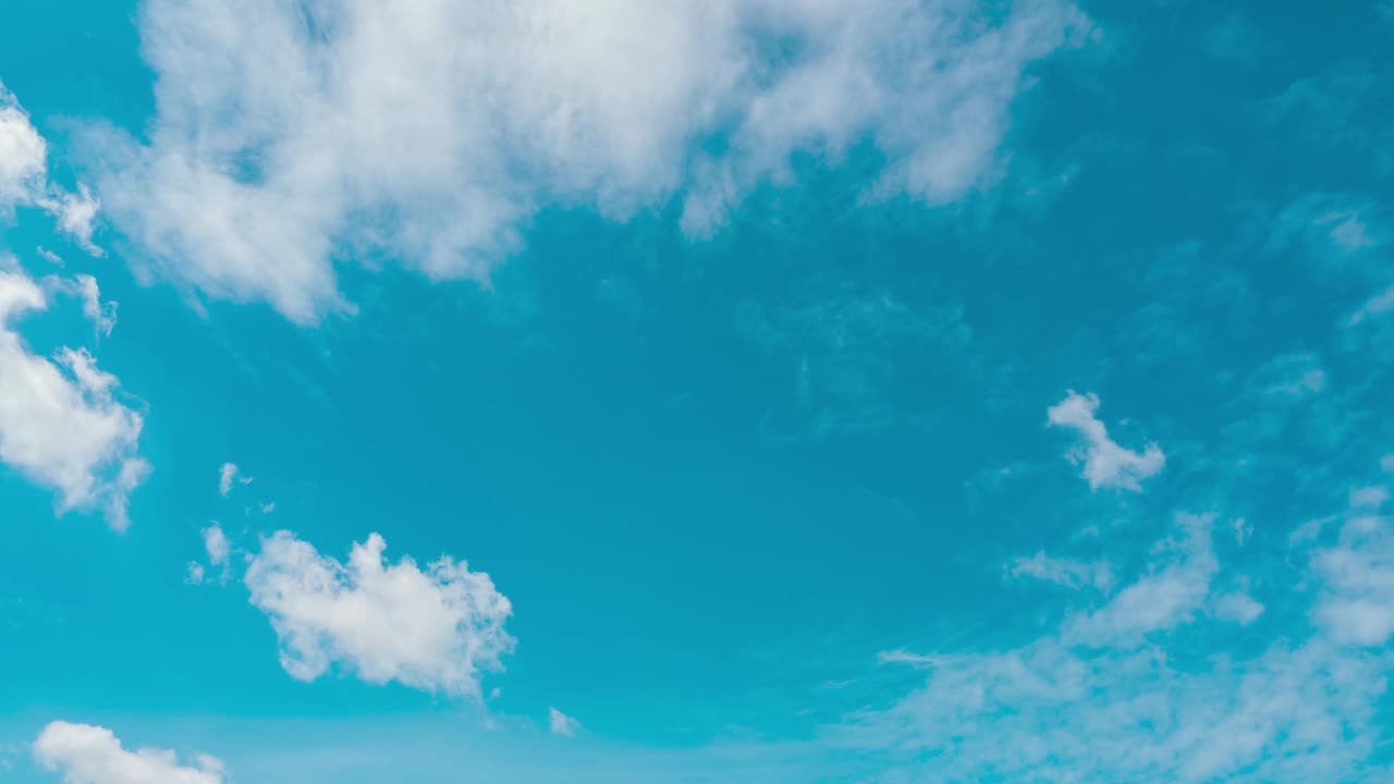 在夏日阳光明媚的日子里，云朵在蔚蓝的天空中移动。蓝蓝的天空飘着蓬松的白云，在春日晴空的广阔空间里遨游。视频素材