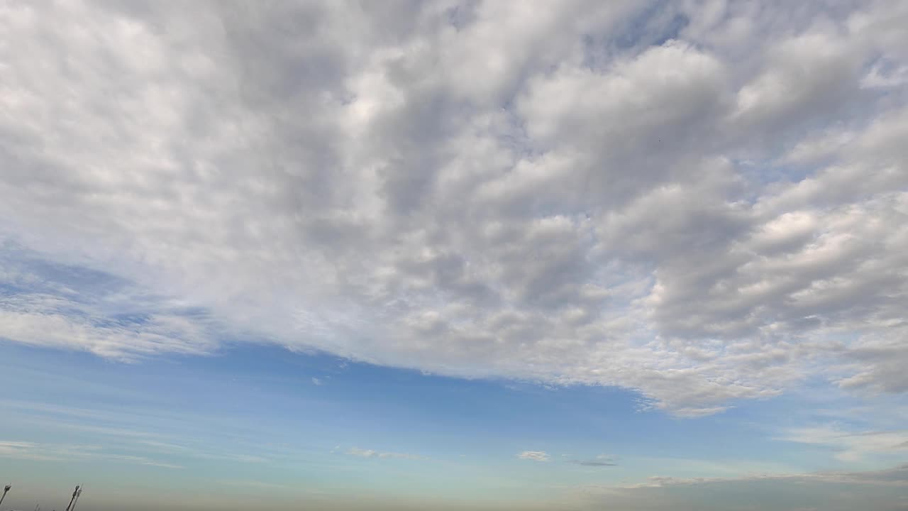 时间流逝4k镜头云景背景在蓝天夏季。白色透明的云，鸟的翅膀或角在天空中飞翔。日出时分天空色彩柔和。大气中的环境。视频素材