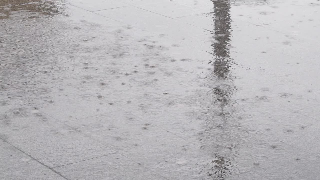 大雨期间的路面。城市道路上的水坑和气泡。下雨的季节。特写视频4k分辨率。视频素材