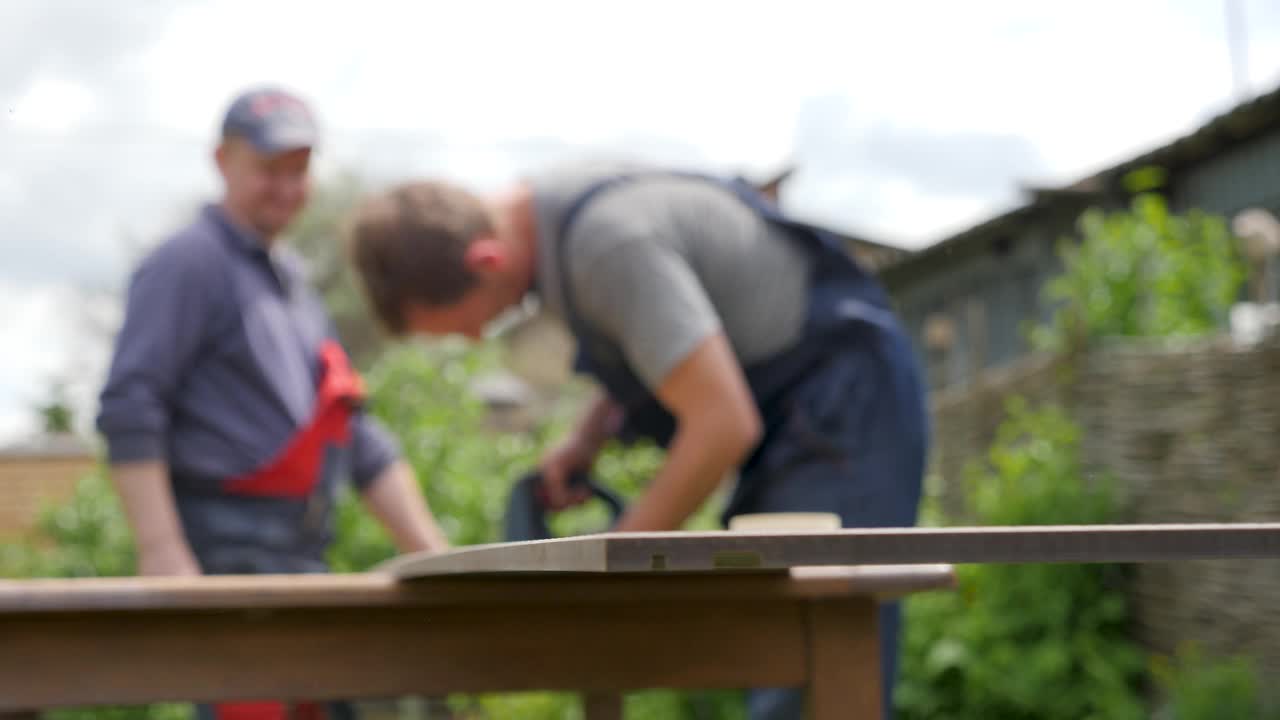 花园房屋修理工具改进diy家庭建筑板木匠工人木材安装。用电锯切割木板的工匠。木工与木板房屋翻新视频素材