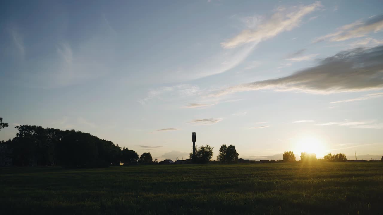 阳光下田野上美丽的夕阳。水塔清晰可见视频素材