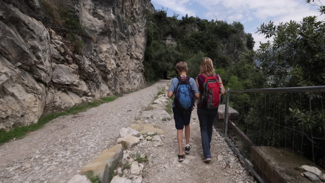 母亲和儿子在意大利加尔达湖旁的Ponale小径上徒步旅行视频素材