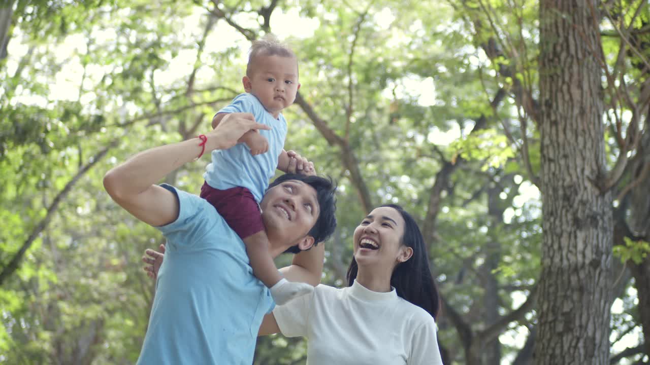 在公园里，男孩和妈妈坐在爸爸的脖子上视频素材