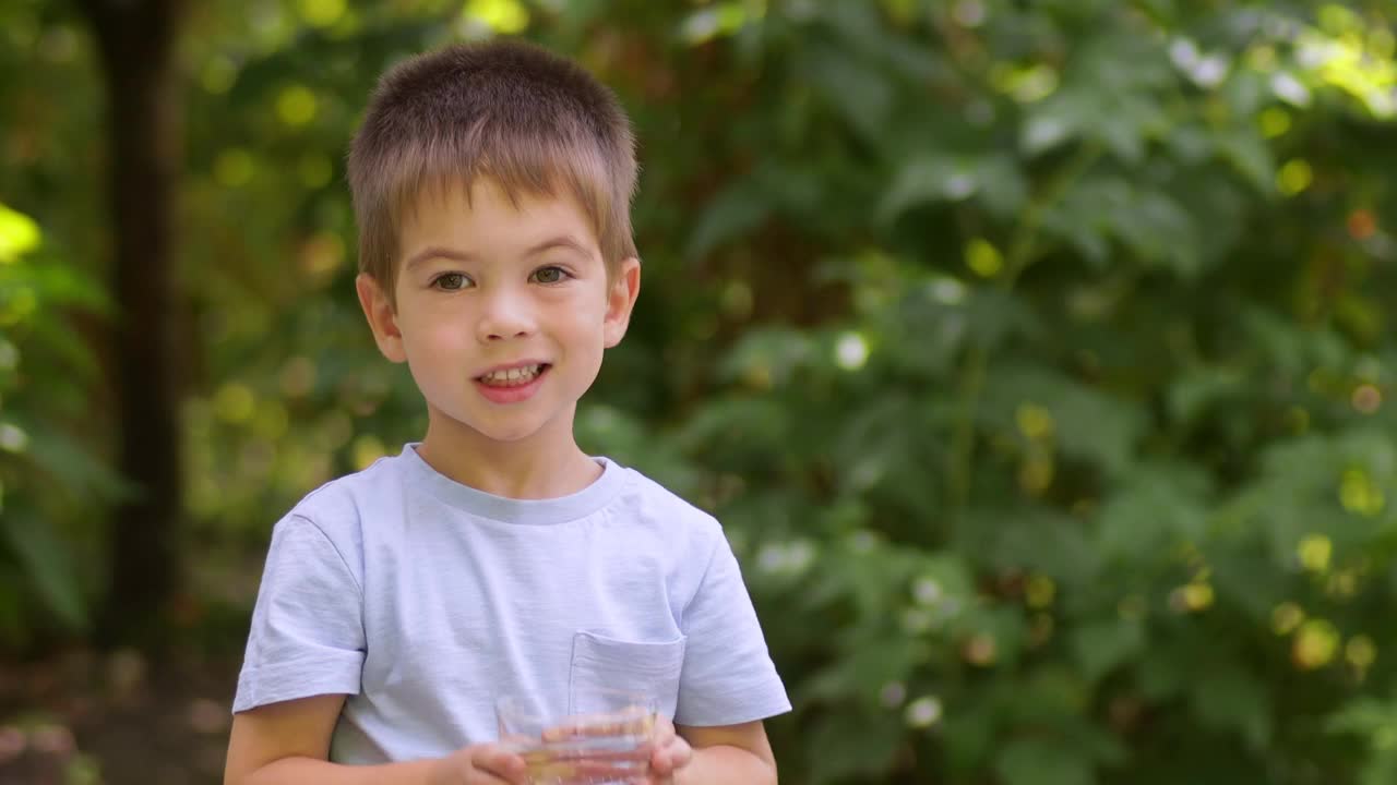 可爱的小男孩在户外喝水视频素材