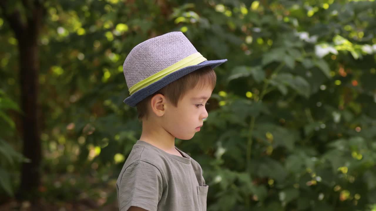 小男孩戴着帽子在户外喝牛奶视频素材