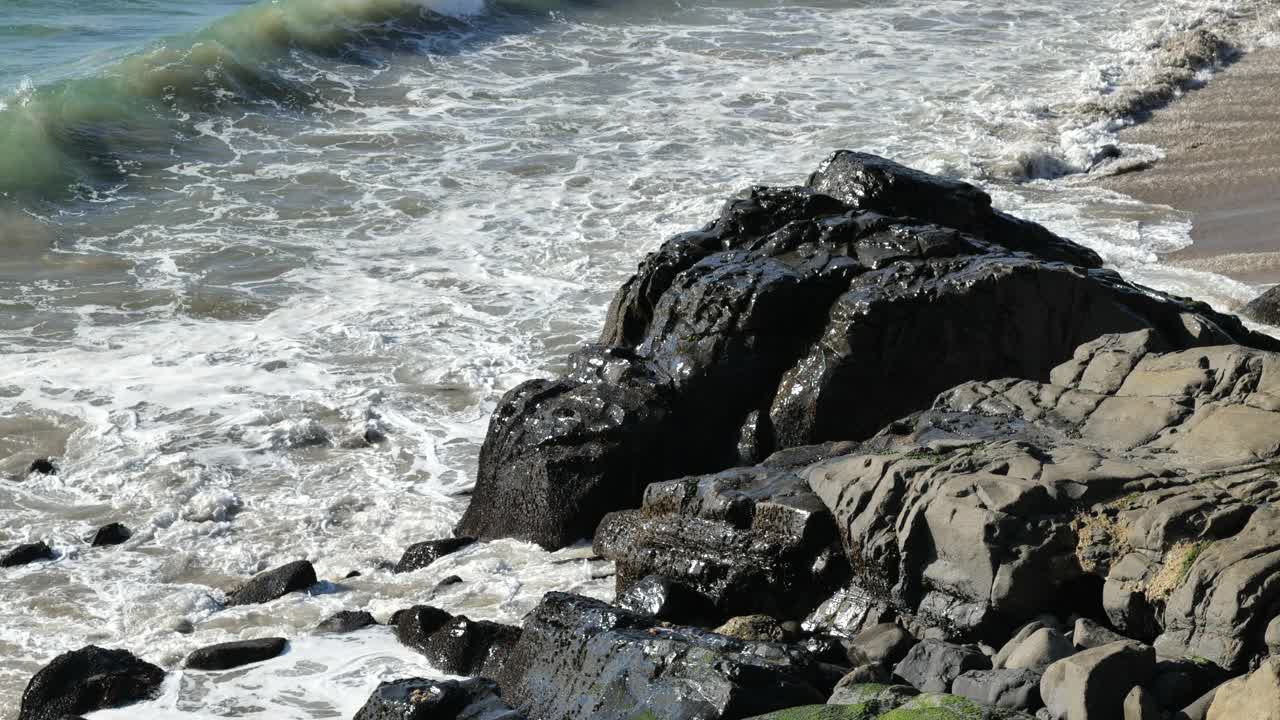 在热带度假胜地，海浪拍打着海岸线上的岩石的高角度视图视频素材