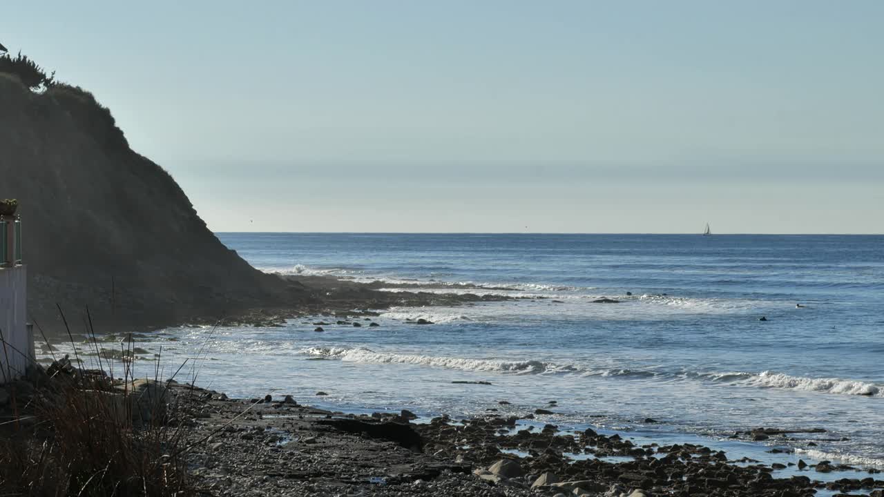 在一个热带度假胜地，海浪翻滚着冲进岩石海岸视频素材