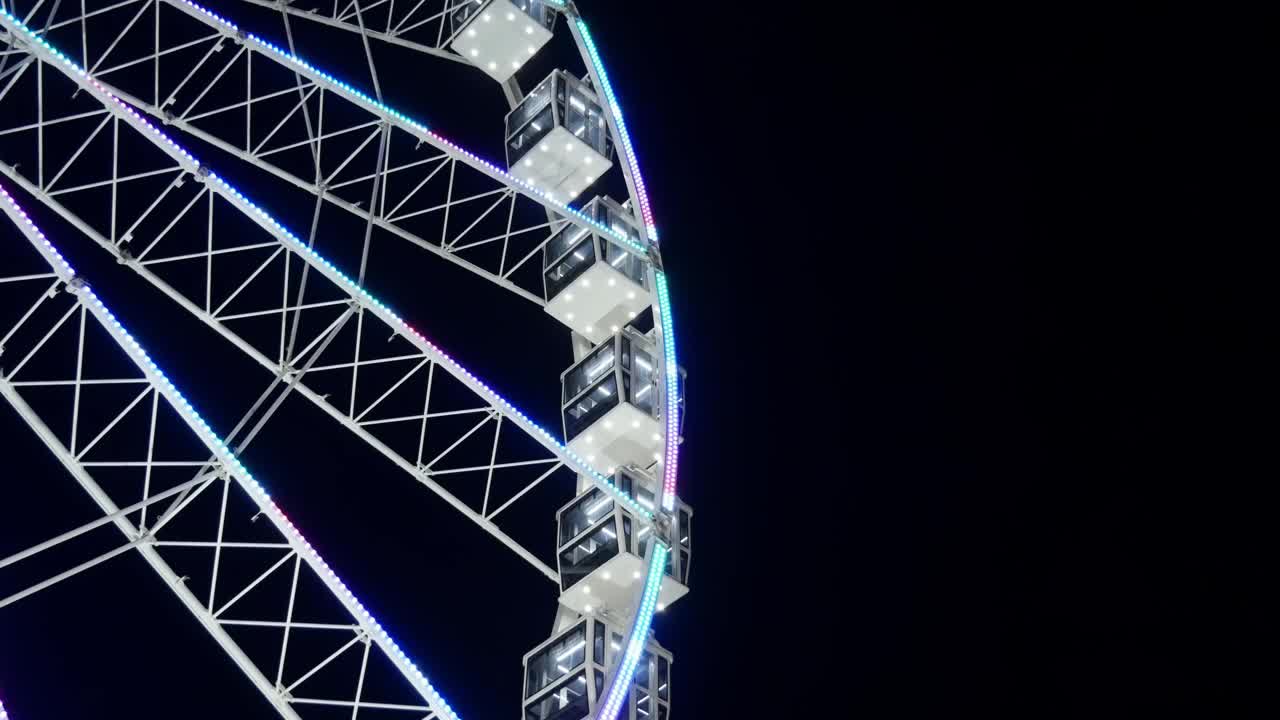 夜间运转的摩天轮，背景中鸟群成群地飞翔视频素材