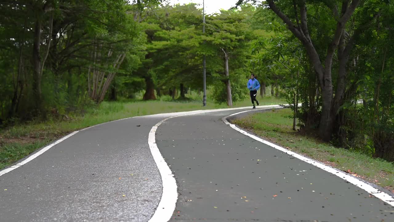 2021年8月10日，健康女性在户外道路慢跑和锻炼，自然公园背景。健康和生活方式概念。视频下载