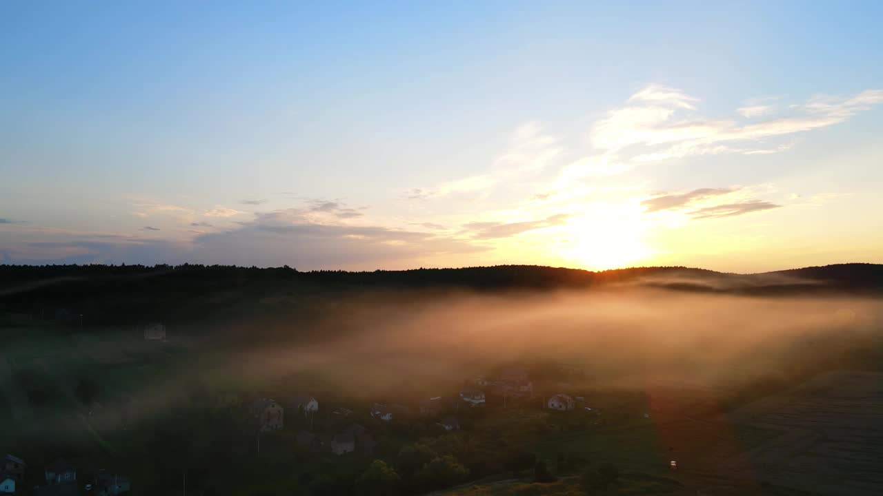 美丽的日落，阳光透过薄雾照耀着黄昏的村庄。风景如画的落日在雾霾中飘落到地上视频素材