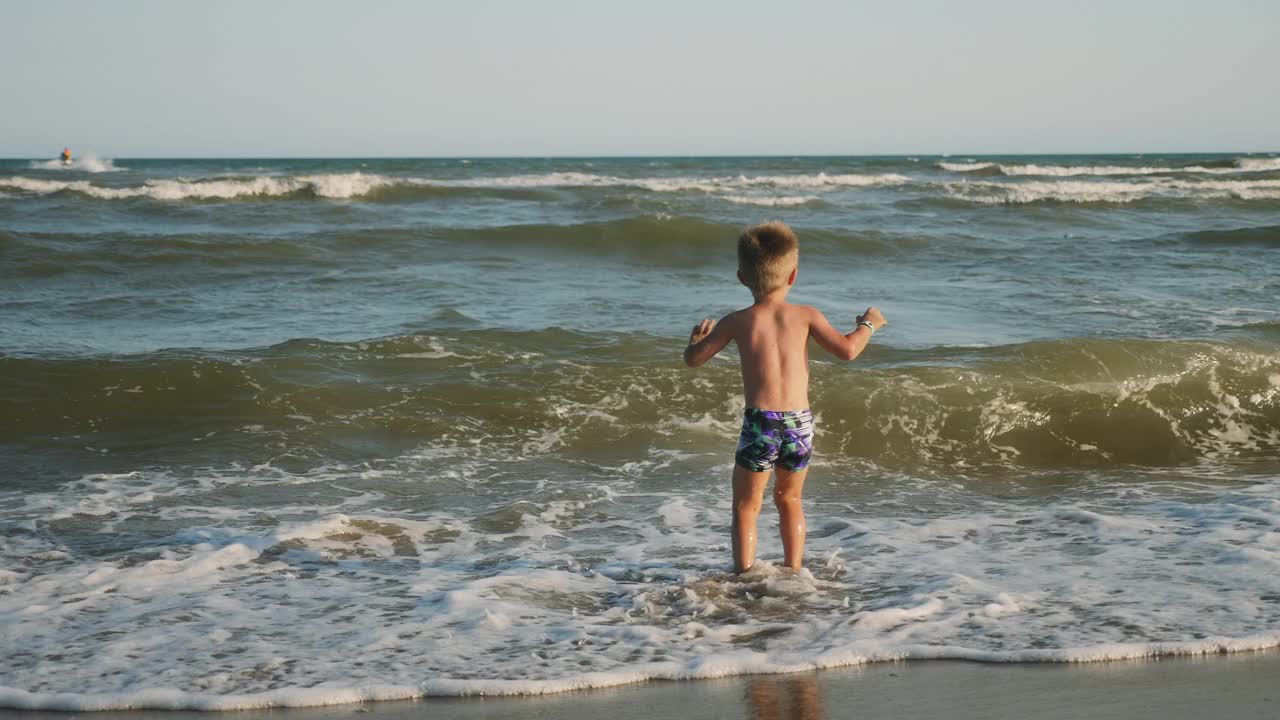 小男孩跳进海浪里视频素材