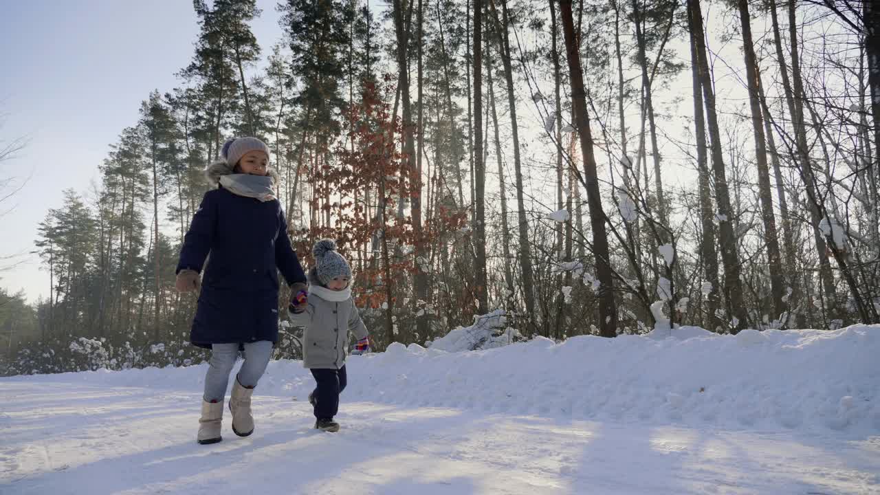 孩子们穿着暖和的衣服在下雪的路上奔跑视频素材