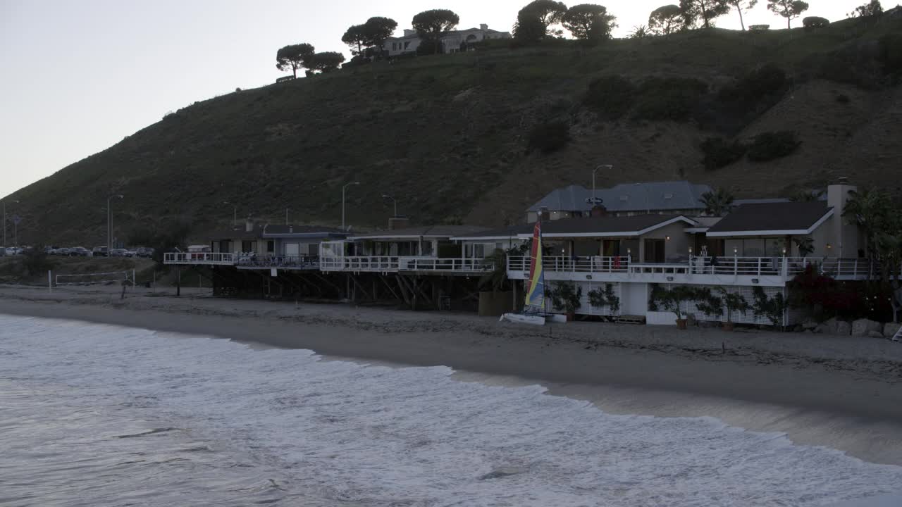 带有露台或阳台的海滨别墅。可以看到海滩和海洋。房子前面可以看到排球网和帆船。视频素材