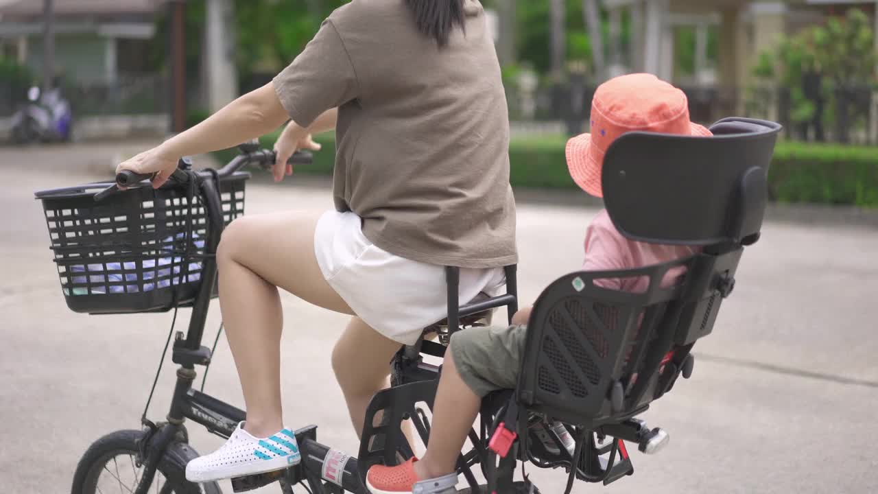 父母骑着自行车，孩子坐在后面。视频素材