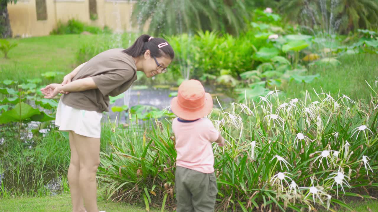 儿子和妈妈在公园里看花视频素材