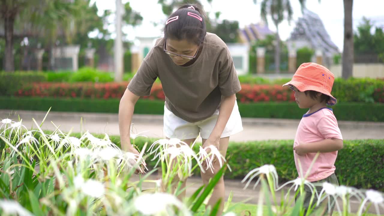 儿子和妈妈在公园里看花视频素材