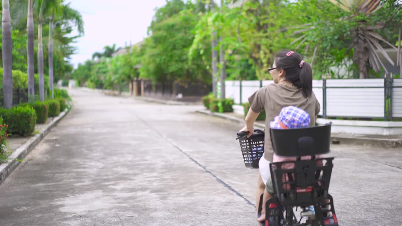 父母骑着自行车，孩子坐在后面。视频素材