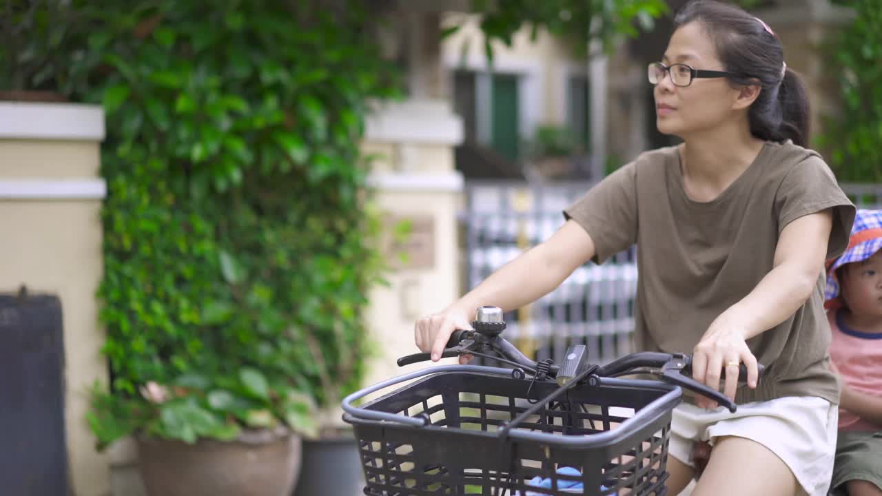 父母骑着自行车，孩子坐在后面。视频素材