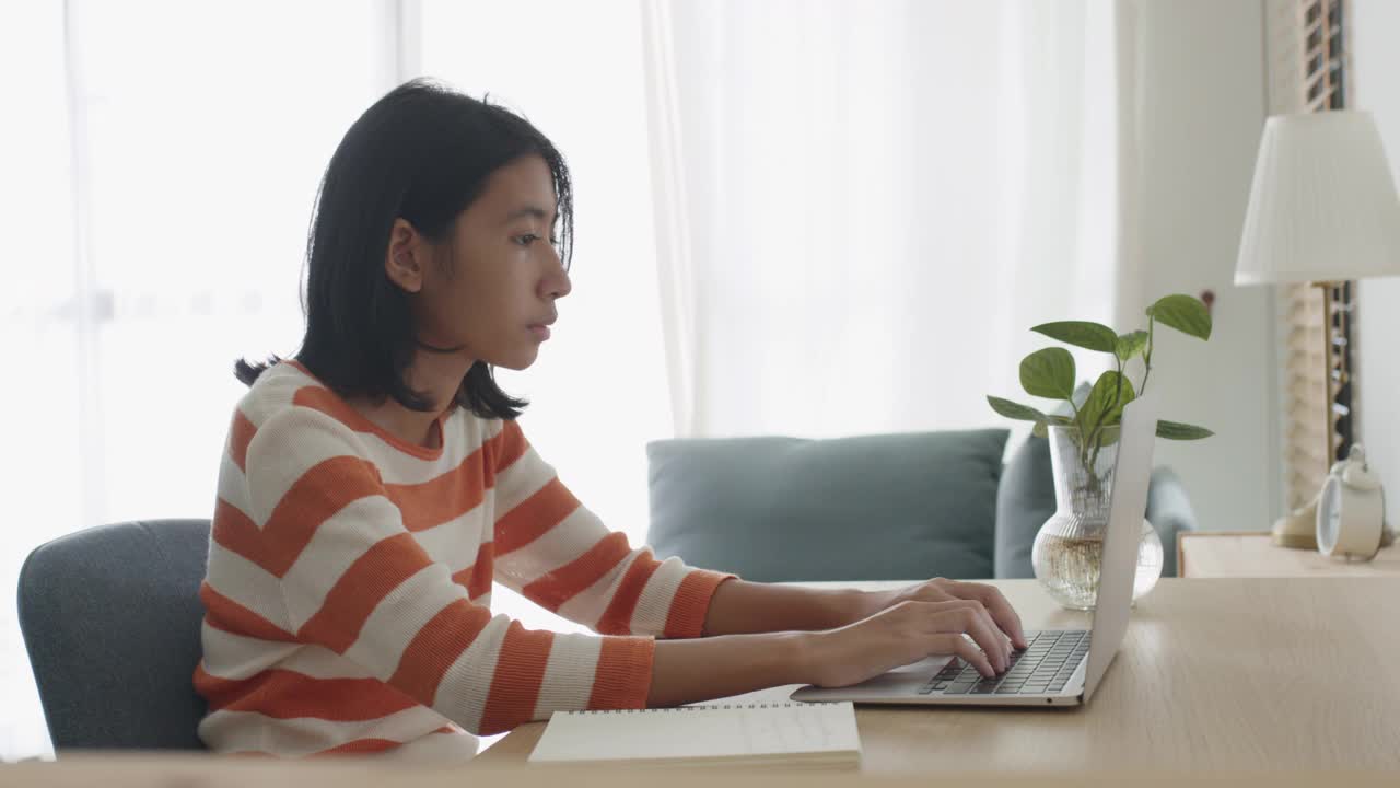 亚洲女孩在家里使用笔记本电脑视频素材