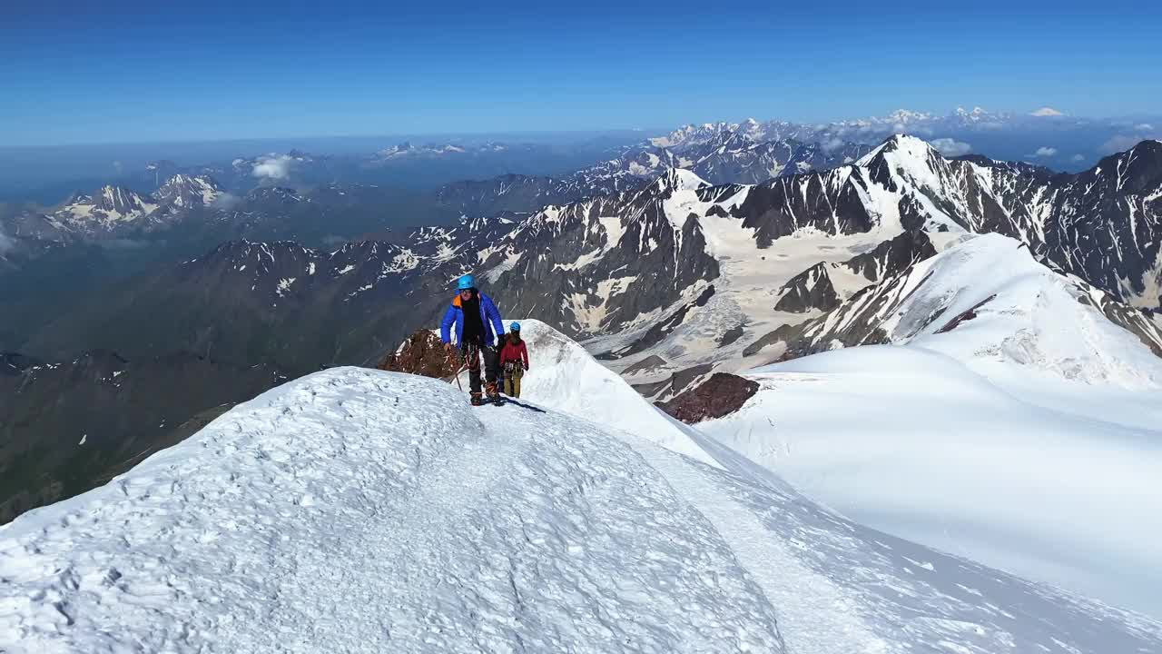 一名手持冰斧的登山者爬上了卡兹别克山的山顶。视频素材