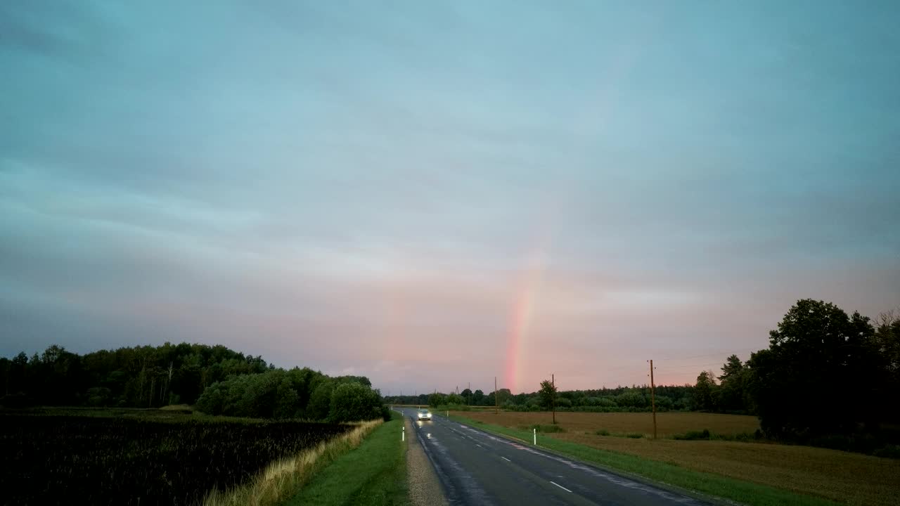 森林和麦田上的双彩虹。乡村公路上的黑色雷雨云和彩虹景观。区域Dron开枪。视频素材