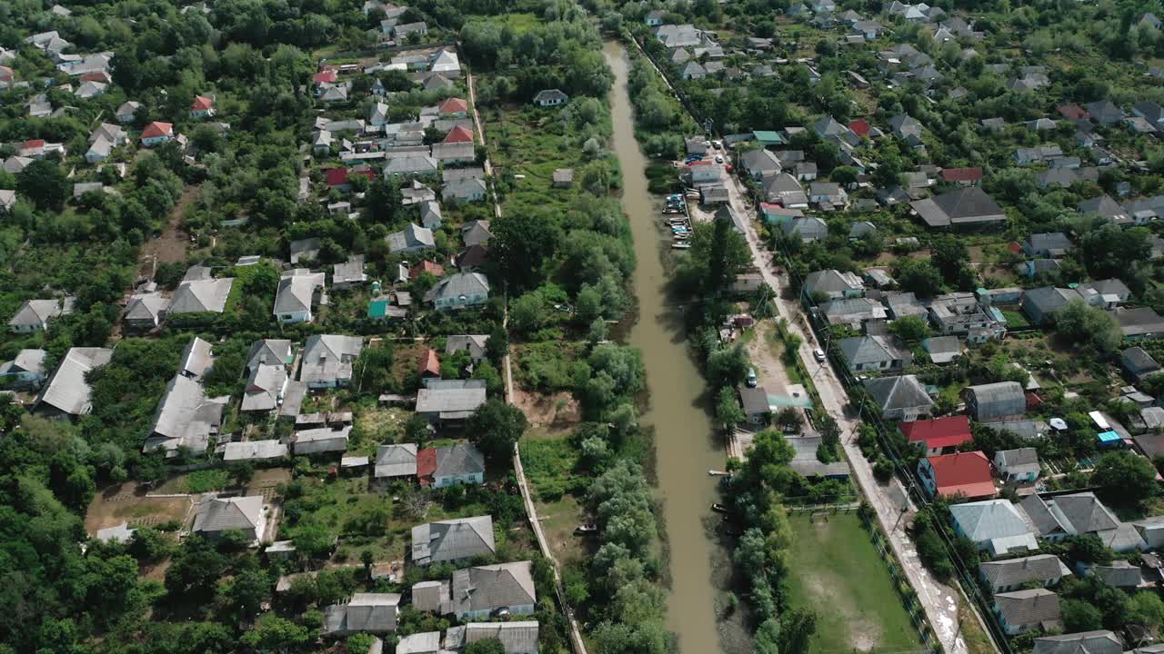 夏日河流从空中流过村庄的景象。视频素材