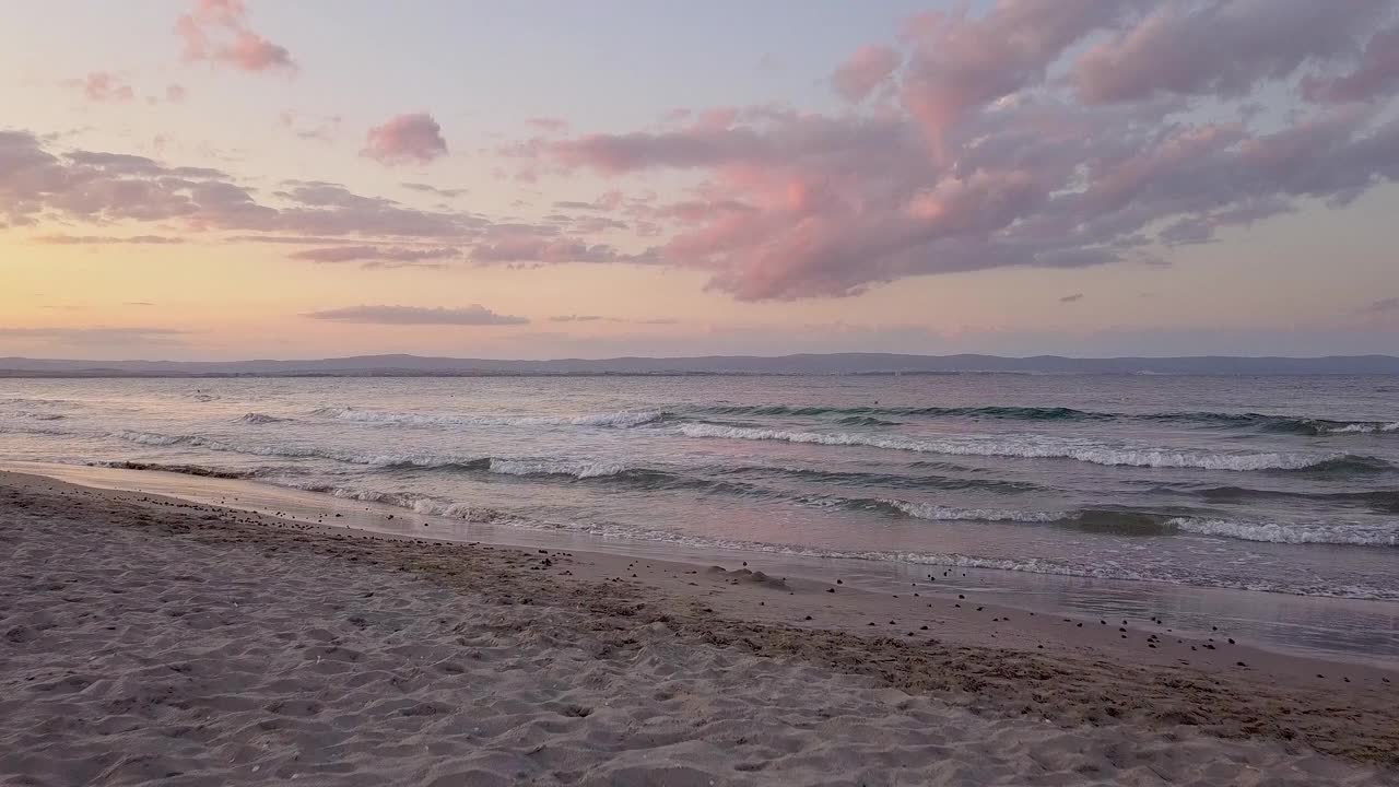 鸟瞰图的海面与蓝色的海浪在日落的天空下。视频素材