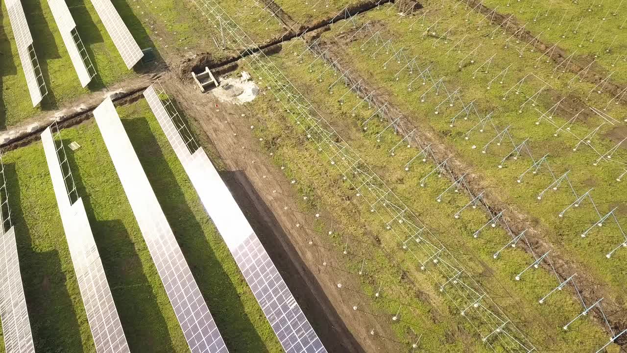 绿地上正在建设的太阳能发电厂鸟瞰图。生产清洁生态能源的电板组装。视频素材