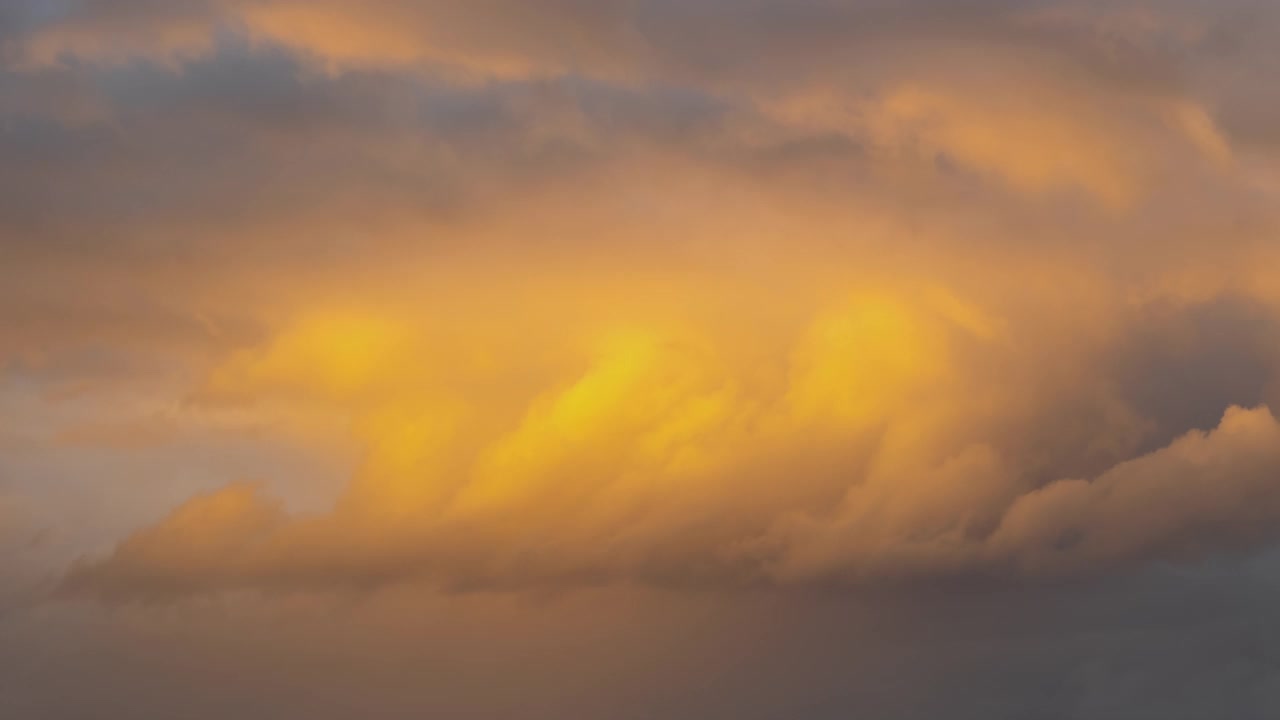 日落时，暗黄色天空上快速移动的暴风雨云的时间流逝。视频素材