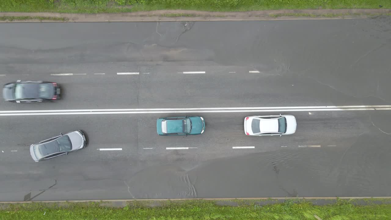 鸟瞰图的城市交通与汽车行驶在洪水后的街道。道路排水系统问题。视频素材