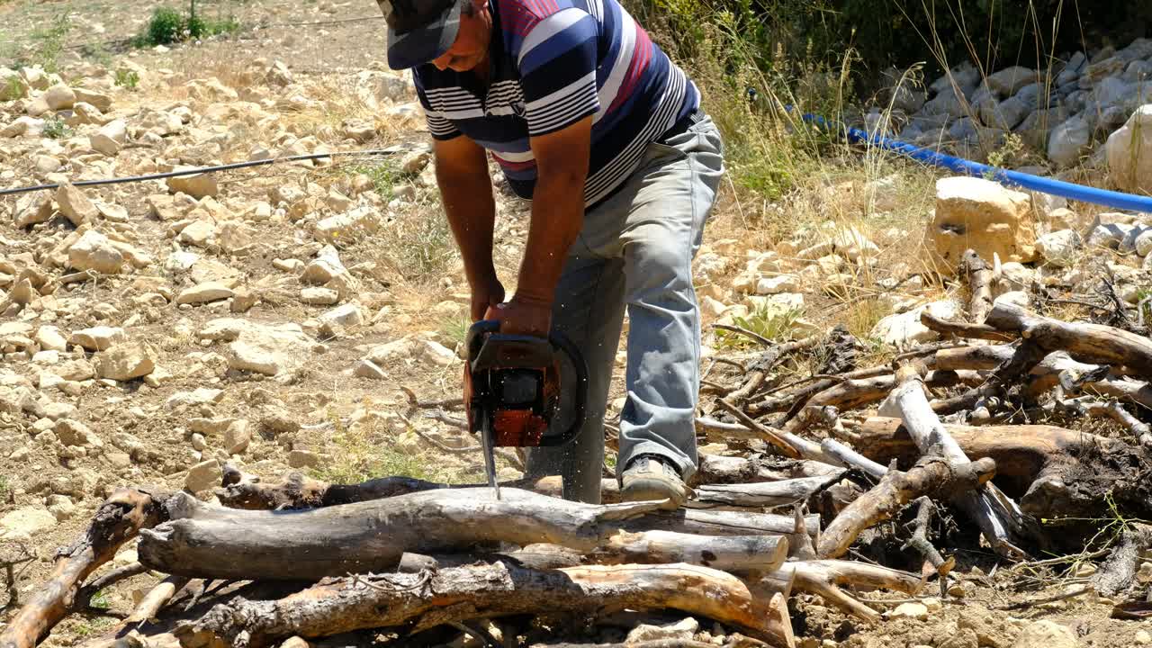 人们在乡村用电锯砍柴视频素材