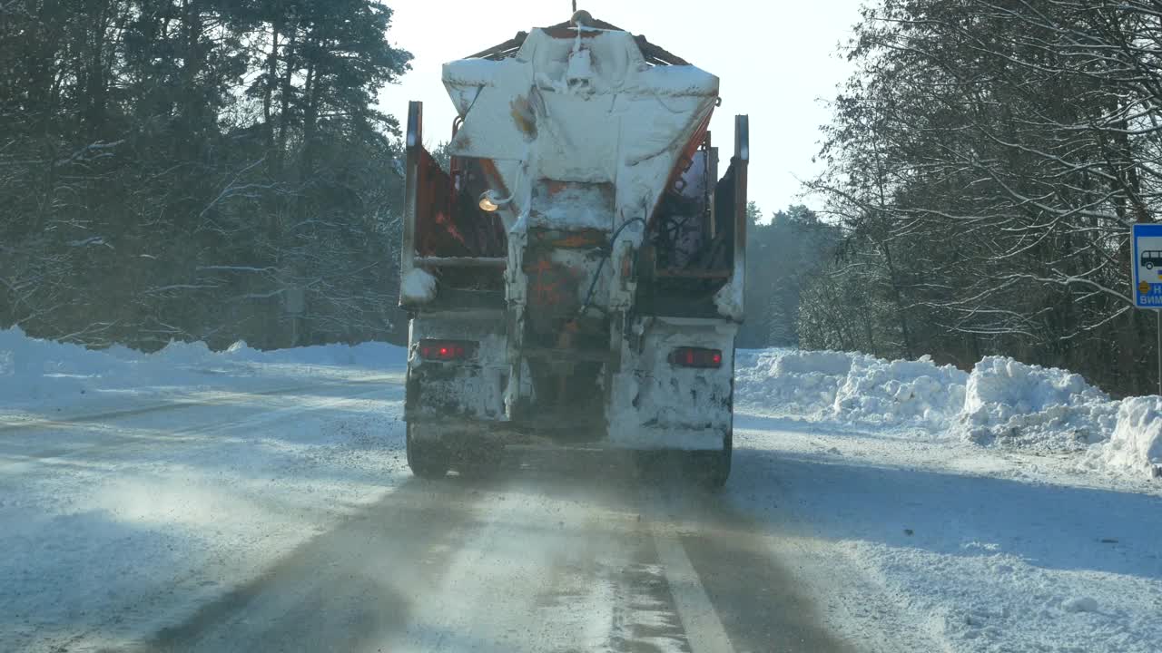 Сar用沙子清理积雪的道路。
下雪时路上的特殊除雪车辆。冬天下雪时的汽车。视频素材