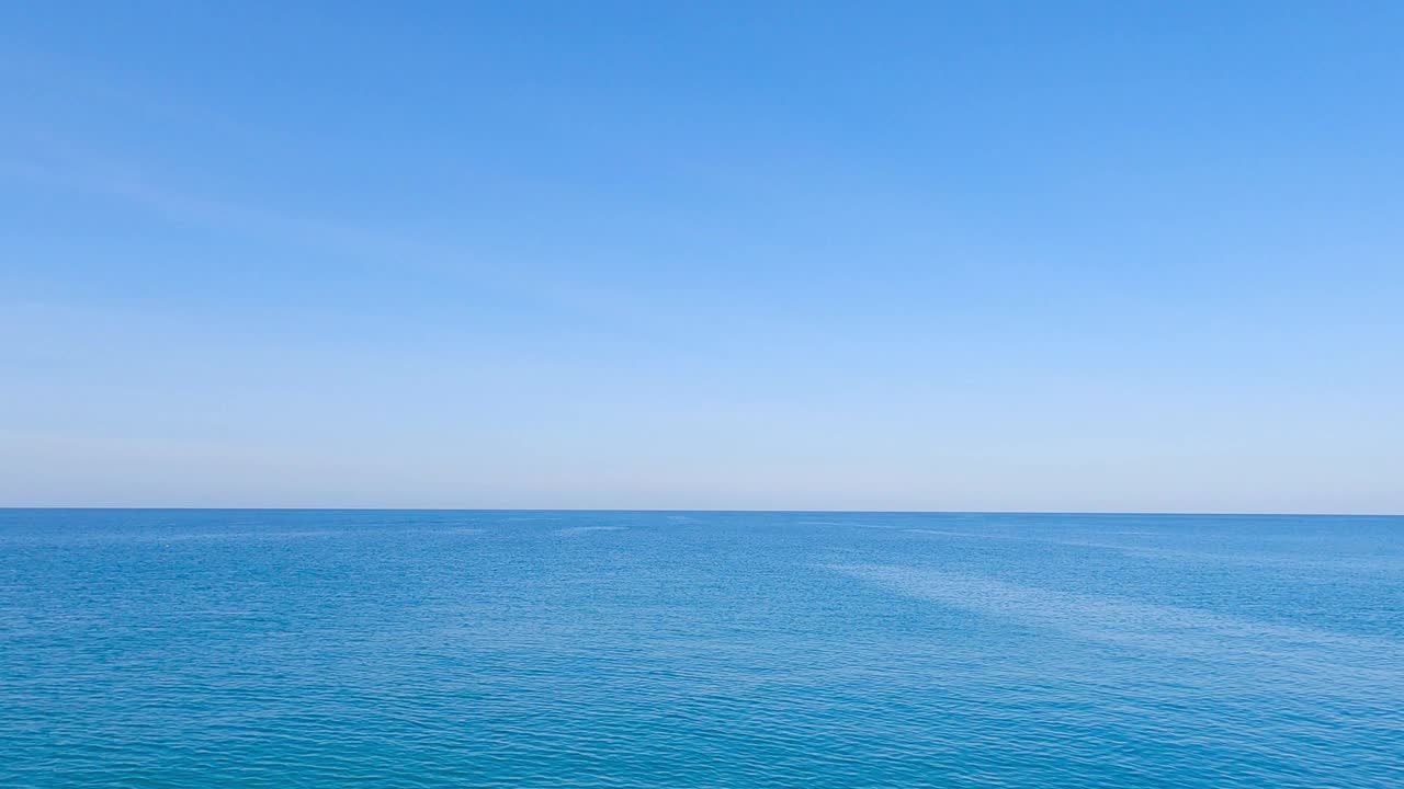 蓝色的海水平静的海浪在晴朗的天空视频素材