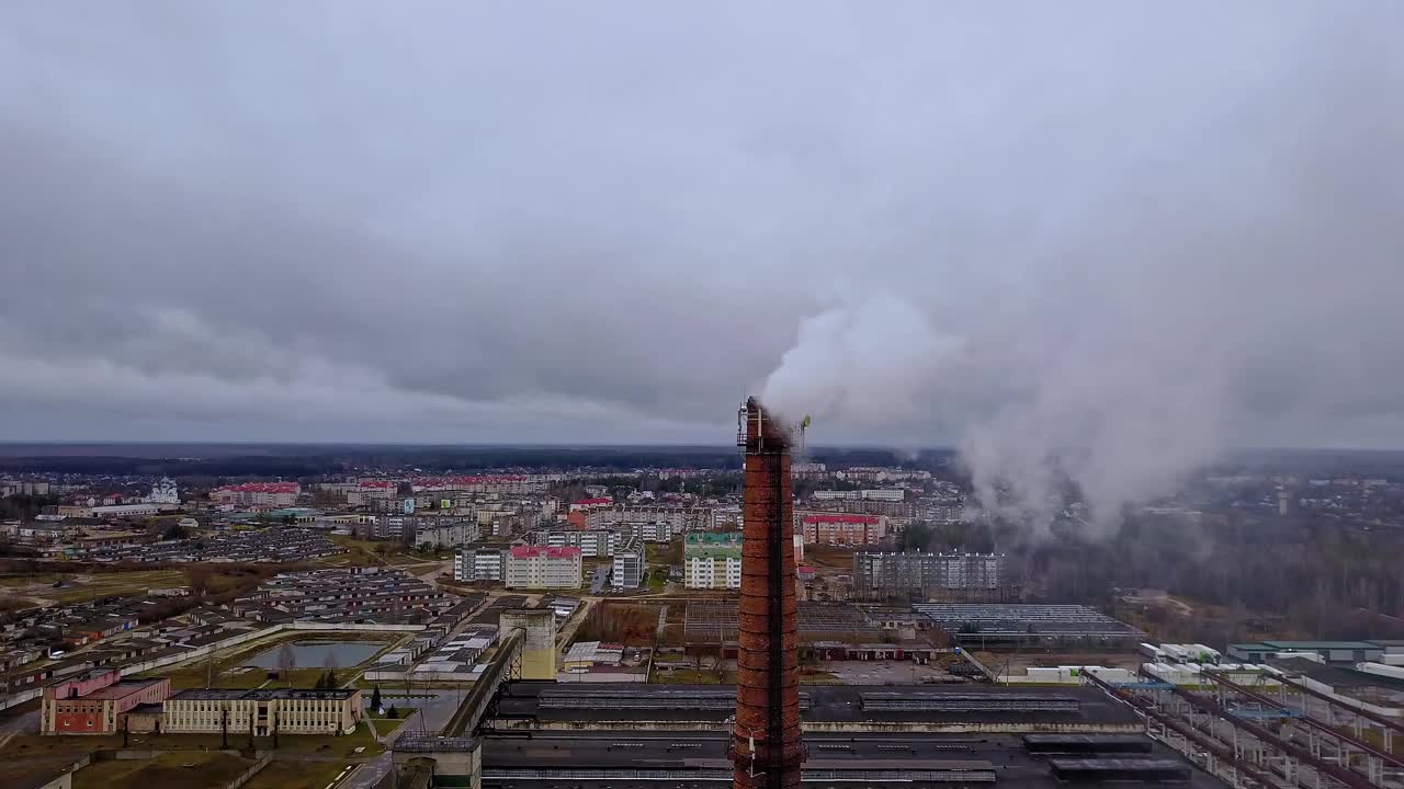 一根喷出白色烟雾的烟斗。城市燃气锅炉房的管道，白色的烟雾映衬着引人注目的天空。鸟瞰图。生态问题。视频素材