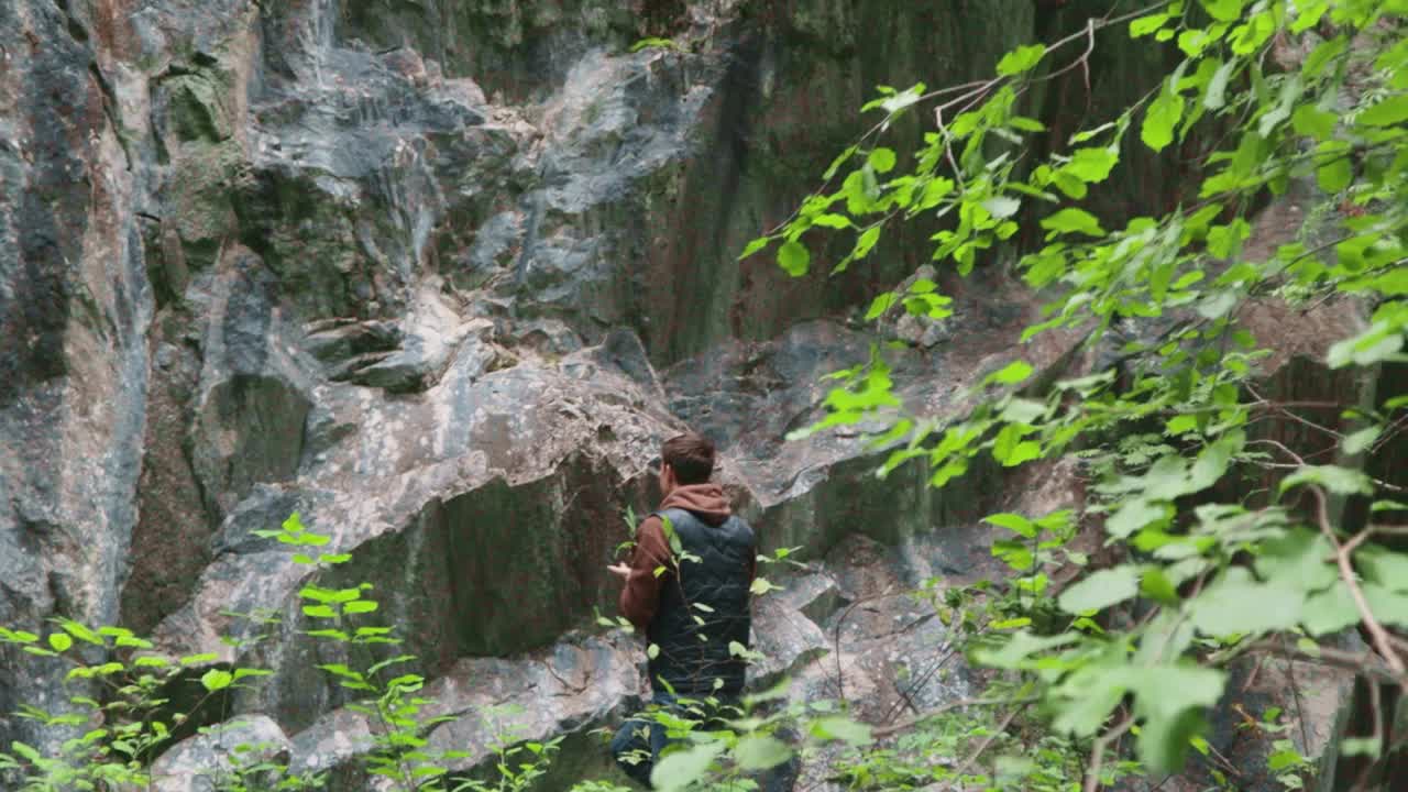 男人旅行者攀登岩石，徒步旅行北方森林视频素材