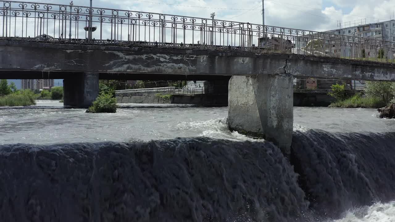 从空中鸟瞰沸腾的Terek河和弗拉季卡夫卡兹的河岸大桥视频素材