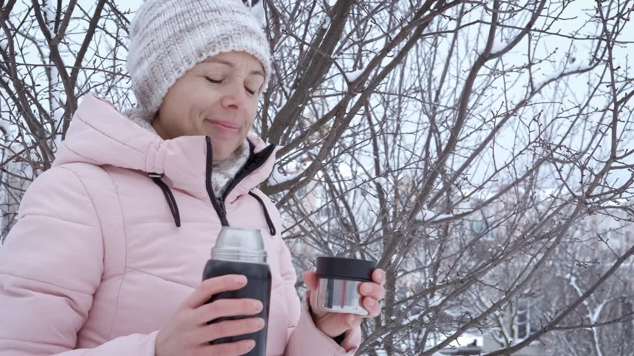 冬天森林里拿着保温瓶的女人。视频素材